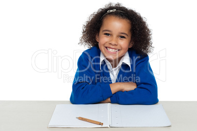 Smiling young school girl doing homework