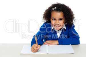 Smiling young school girl doing homework