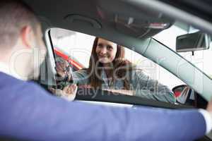 Woman giving car keys to a customer
