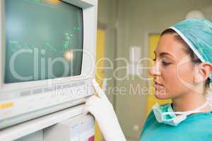 Smiling female surgeon standing next to a monitor