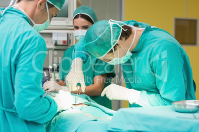 Surgeons working with a scissors on a patient