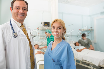 Smiling doctor and nurse talking in a hospital room