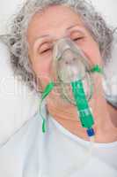 Elderly closing her eyes while lying in a hospital bed