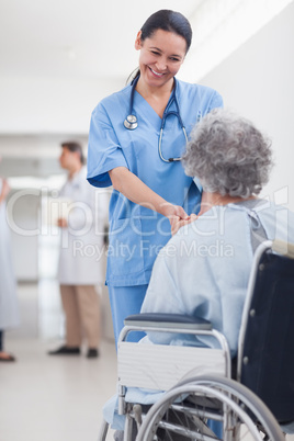 Doctor greeting recovering senior patient in wheelchair
