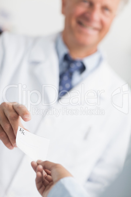 Customer handing a Rx prescription to a pharmacist