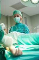 Intern watching the surgery while holding an oxygen mask