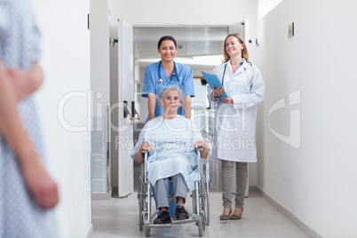 Smiling nurse assisting senior woman sitting in a wheelchair