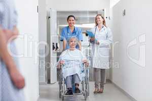 Smiling nurse assisting senior woman sitting in a wheelchair