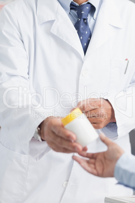 Pharmacist giving a box of pills to someone