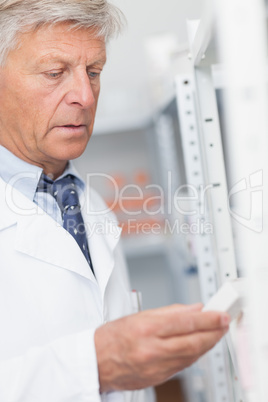 Pharmacist looking at pills in a shelf Pharmacist looking at pills in a shelf