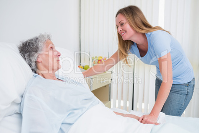 Smiling woman holding the hand of a patient in a room