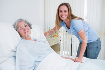 Woman holding the hand of a patient in a room