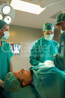 Team of surgeons working on a female patient