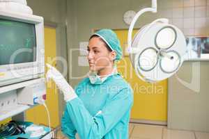 Female surgeon standing next to a monitor