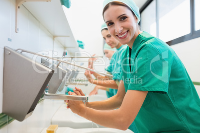 Surgeons washing their hands while smiling