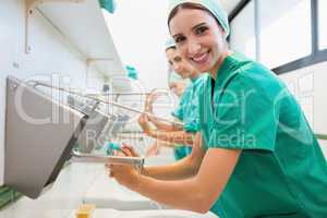 Surgeons washing their hands while smiling