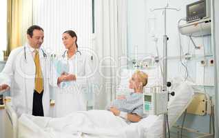 Pregnant patient in her bed talking with doctors