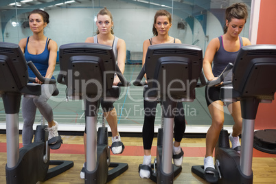 Four women working out at spinning class