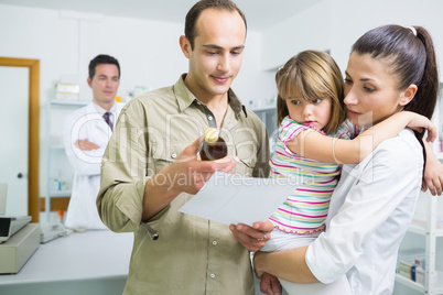 Family looking at medicine and a prescription in a pharmacy