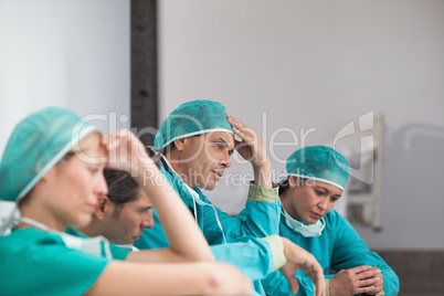 Group of sad surgeons sitting on the floor