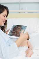 Happy mother using a tablet to take a picture of a newborn baby