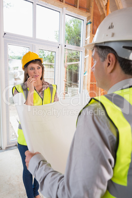 Architect and woman discussing blueprint