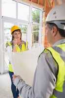 Architect and woman discussing blueprint