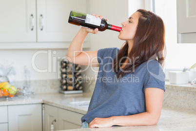 Woman drinking a bottle of wine alone