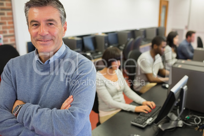 Teacher smiling at top of computer class