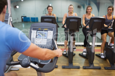 Man teaches spinning class to happy women