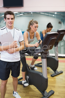 Instructor at spinning class with two women