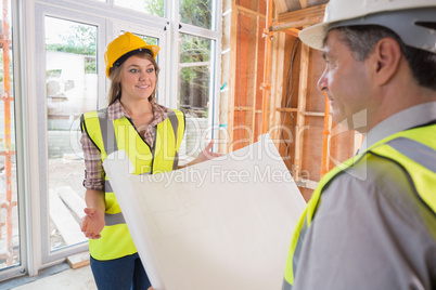 Woman and architect discussing blueprint