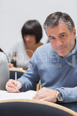 Man looking up from taking notes and smiling