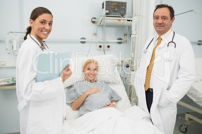 Female and male doctor standing next to a woman patient