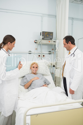 Doctors standing next to a patient