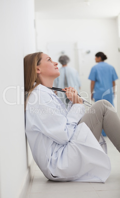 Thoughtful doctor sitting on a hallway
