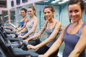 Happy women on exercise bikes