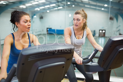 Two women working out on exercise bikes