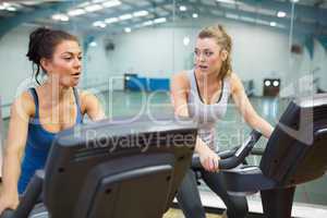 Two women working out on exercise bikes