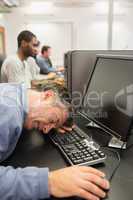 Man sleeping at the keyboard in computer class