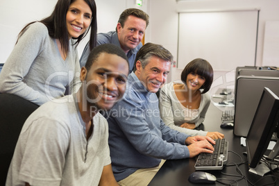 Teacher and students sitting at the computer