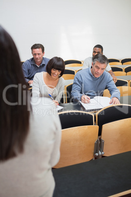 People taking notes in a lecture