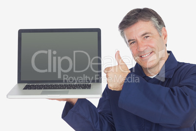 Mechanic with laptop showing thumbs up sign