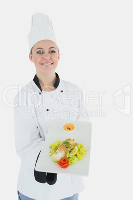 Chef in uniform offering plate of healthy food