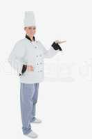 Portrait of female chef holding out your product