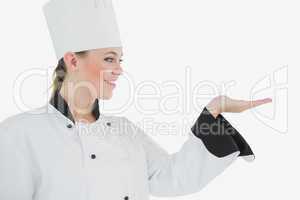 Happy female chef looking at invisible product