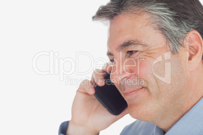 Mature businessman smiles while on call