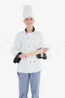 Happy female chef holding rolling pin