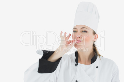 Female chef in uniform blowing a kiss