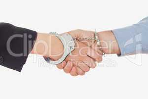 Business people in handcuffs shaking hands
